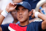 Rinky Hijikata adjusts his cap during a US Open match against Frances Tiafoe.