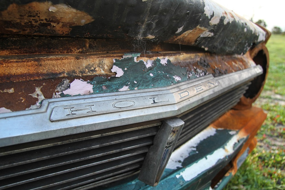 Detail photo of the grille of a burned-out car wreck.