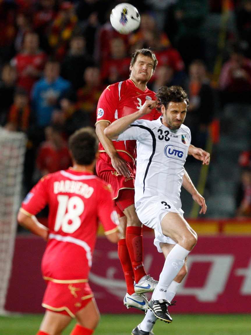 Inseparable ... Adelaide's Nigel Boogaard and Bunyodkor's Jan Kozak slug it out in Adelaide.