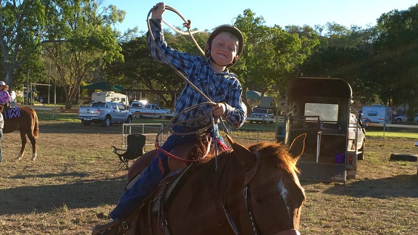 8yo Cooper Hall, seated on his stationary horse, twirls a lasso rope above his head at the Adelaide River junior rodeo