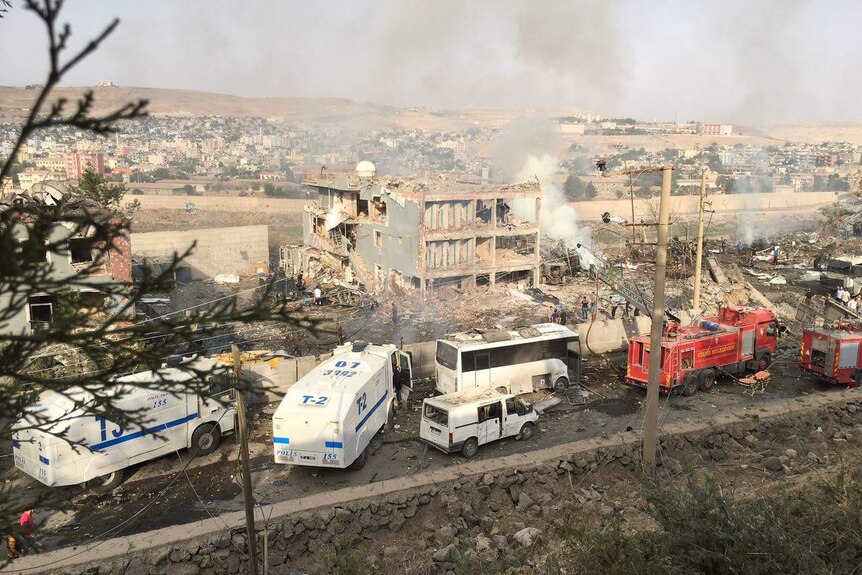 Turkish police and firefighters are parked near the damaged police headquarters.