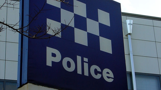 Exterior of Albany police station with police sign in foreground.