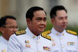 Prayuth Chan-ocha wears a crisp white military uniform with medals and golden epaulets.