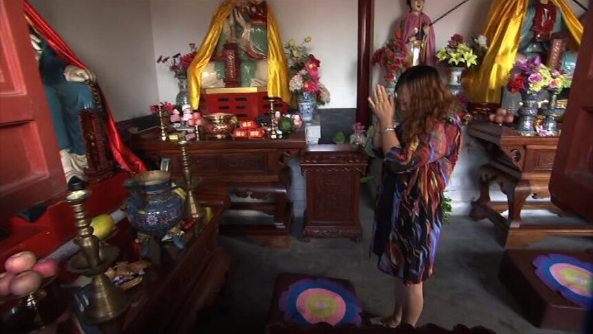 A Daoist worshipper prays on a mat