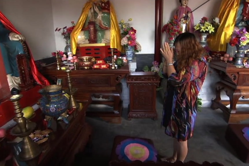 A Daoist worshipper prays on a mat