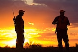Three hunters at sunrise.
