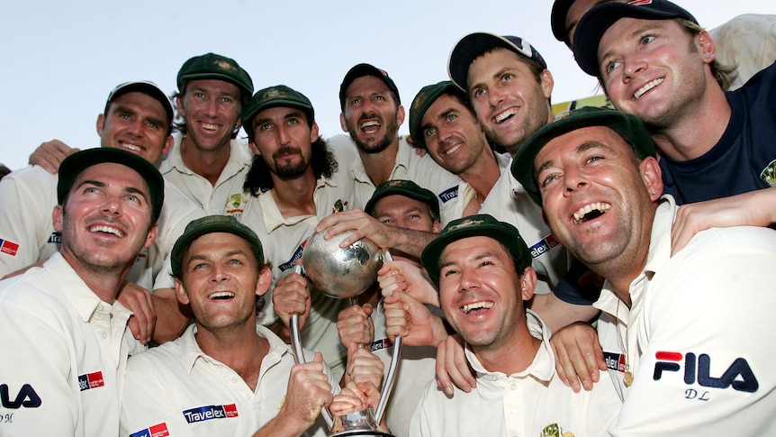 The Australia team holds a large trophy and smiles
