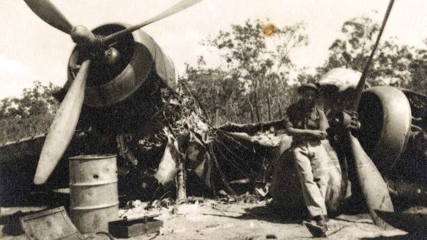 Bob Knight stands amongst wreckage of Beaufighter plane caught on the ground at Milingimbi during World War II