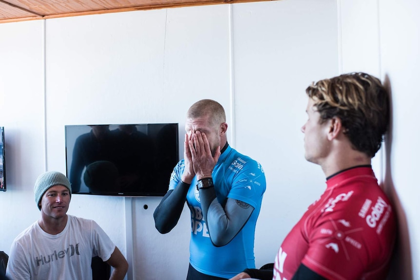 Mick Fanning holds his head in his hands after shark attack