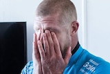 Mick Fanning holds his head in his hands after shark attack