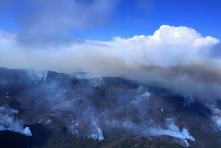 Smoke rises from rugged bushland in Tasmania's Lake Mackenzie area.