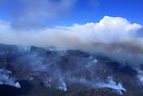 Smoke rises from rugged bushland in Tasmania's Lake Mackenzie area.