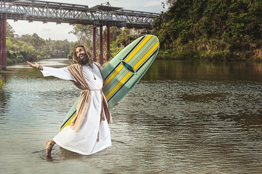 One of the Beards of Ipswich models posing in the Brisbane River at Ipswich with a surfboard.