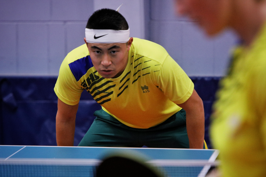 Table tennis player Heming Hu looks over the table.