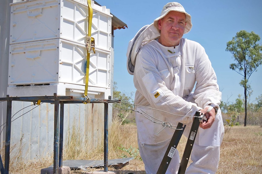 Beekeeper Mick Olsen demonstrates securing a bee hive to the ground with star pickets