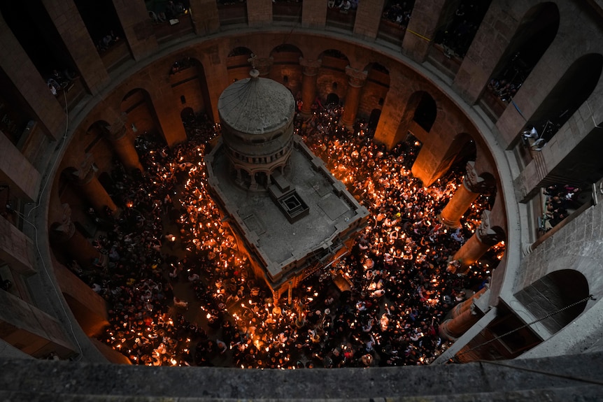 A view from above of candles glowing in a circle surrounding the church.