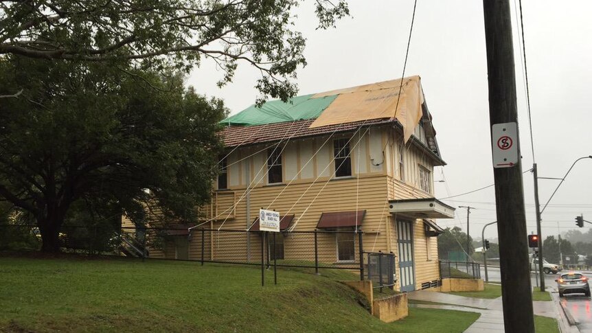 Tarp over roof of house in Brisbane as east coast low makes its way down Queensland coast
