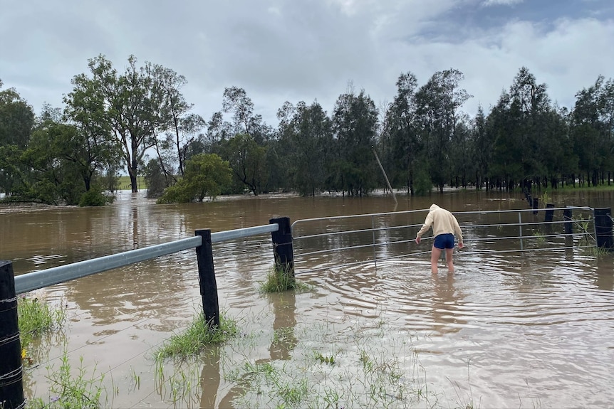 Man stands in floodwater.