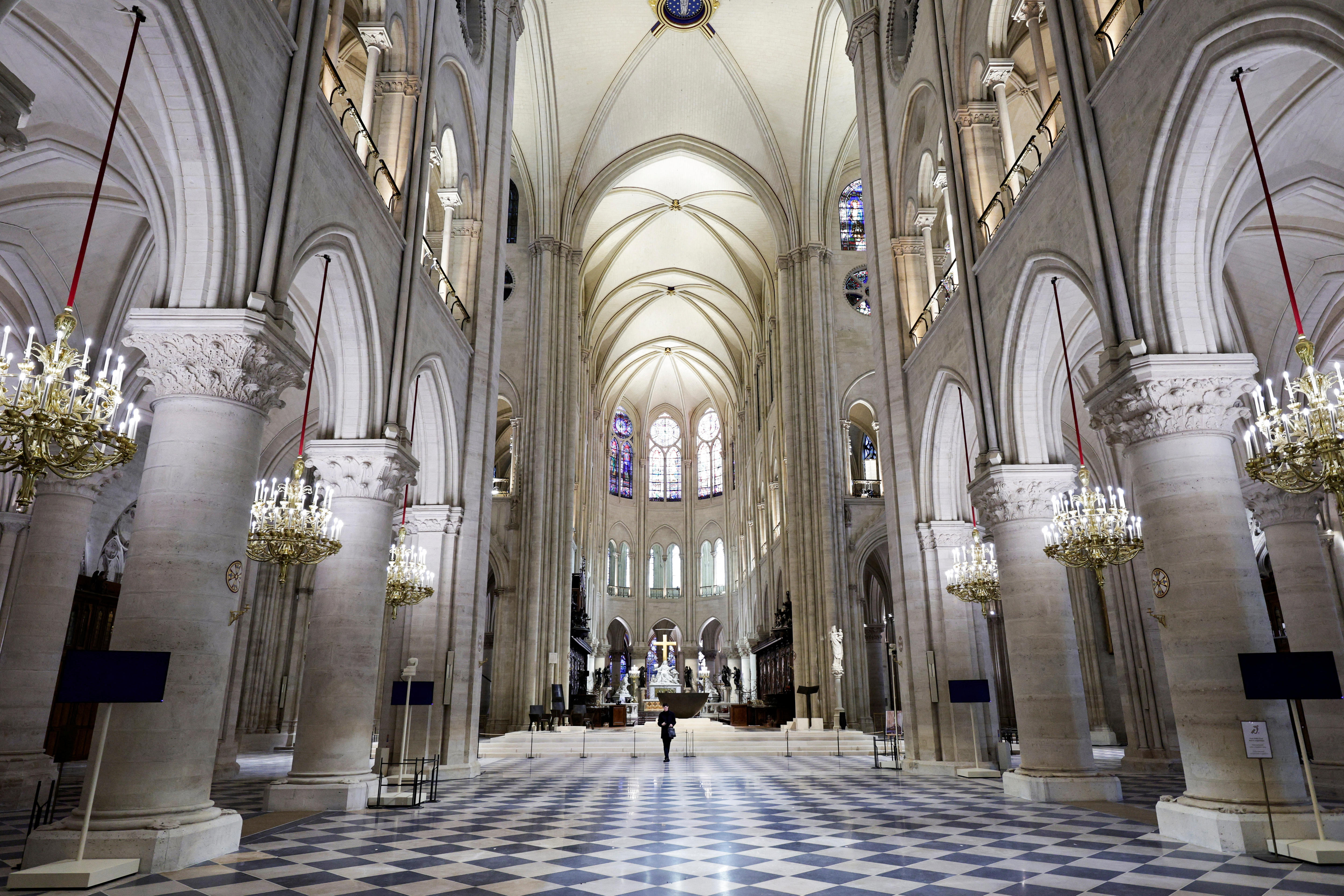 Inside a huge church with white marble and domed roof, complete with golden candelabras