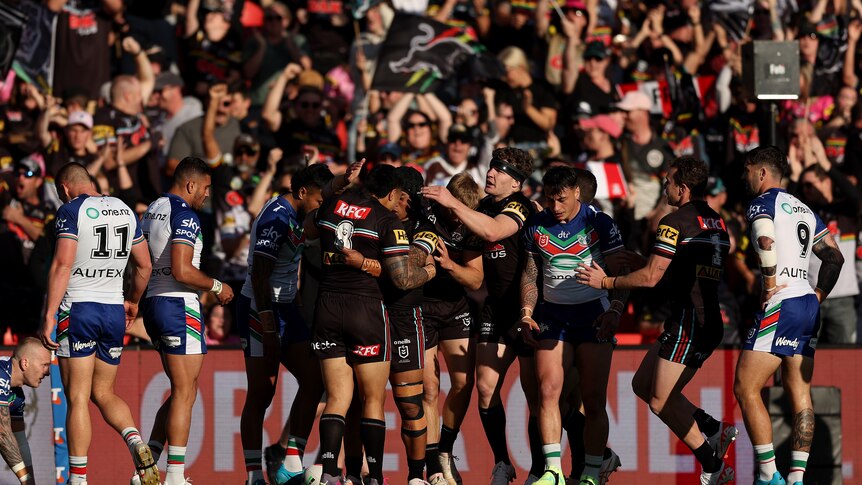 A team celebrates after scoring a try in a rugby league match