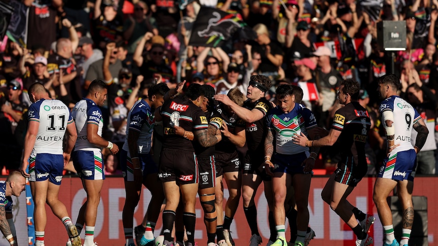 A team celebrates after scoring a try in a rugby league match