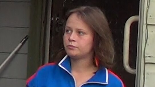 A young girl in a blue tracksuit.