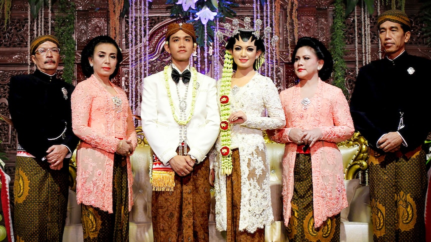 A group of people pose at an Indonesian wedding 