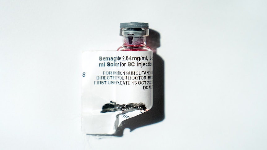 A small vial of red liquid on a white background. it has a label medication label on it which says 'Semaglutide' and other text.