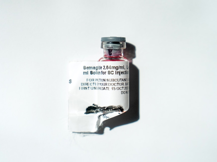 A small vial of red liquid on a white background. it has a label medication label on it which says 'Semaglutide' and other text.