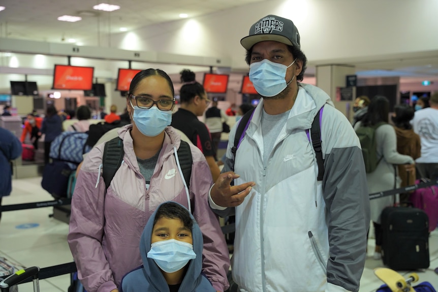 A family of three consisting of a woman in a pink jacket, man in a grey jacket and a young child wearing a hoodie.