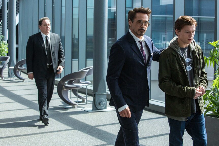 Tom Holland and Robert Downey Jr walk through an office space in a scene from Spider-Man: Homecoming.