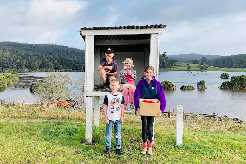 Four small children stand in front of floodplain 