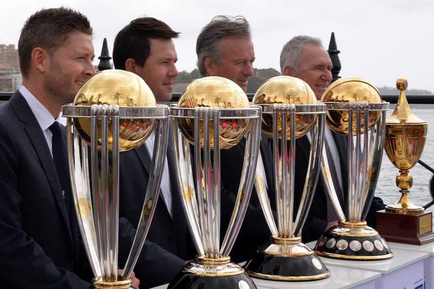 Four former Australian cricket captains pose with the World Cup trophy.