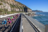 Cyclists ride across the sea cliff bridge north of Wollongong