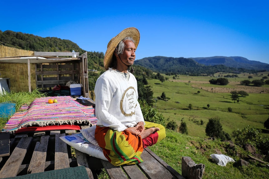 Pairoj Brahma meditating with mountains in the distance