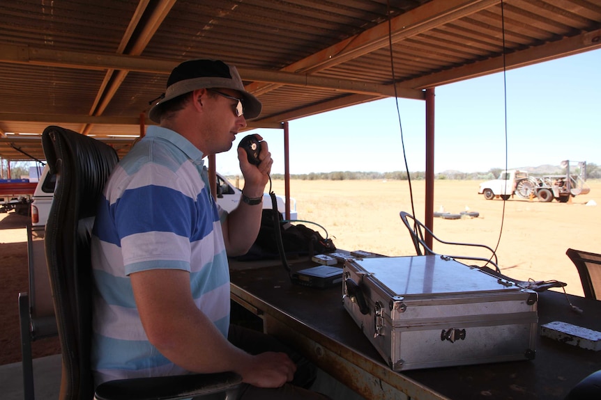 A man speaks over a two-way radio at the Alice Springs gliding club