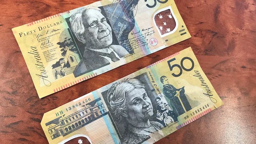 Real and counterfeit 50 dollar notes side by side.