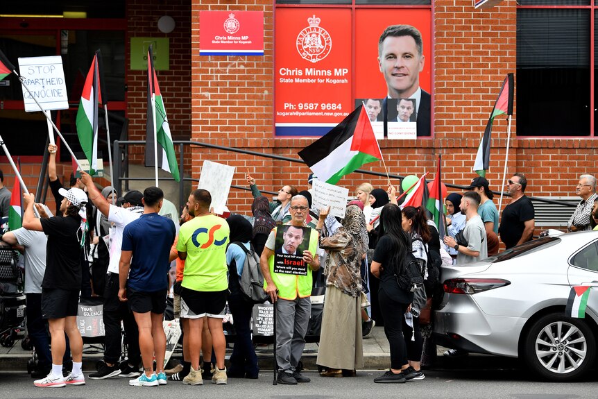 Protesters hold placards and flags during a Pro-Palestine demonstration outside the electoral office of NSW Premier Chris Minns
