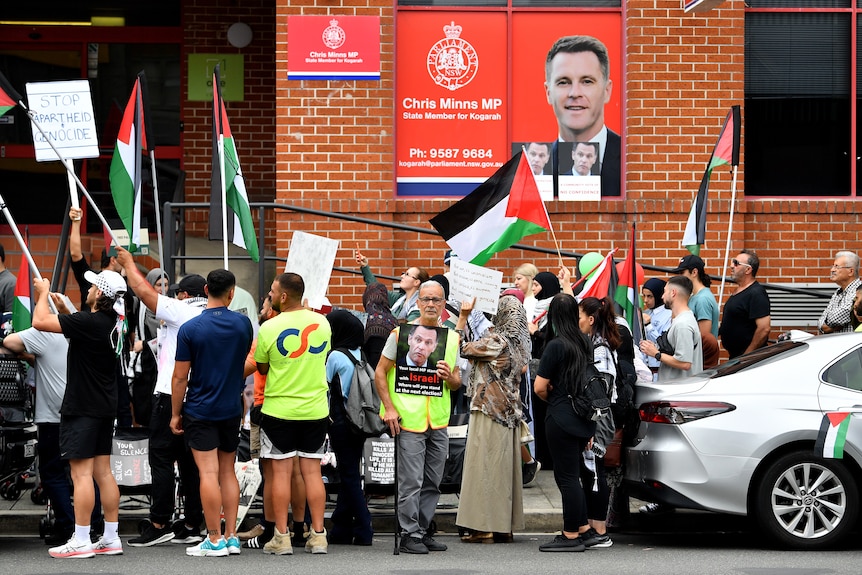 Protesters hold placards and flags during a Pro-Palestine demonstration outside the electoral office of NSW Premier Chris Minns