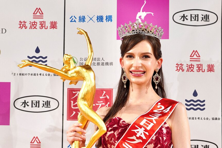 Karolina Shiino poses for photos with a gold Miss Japan trophy. 