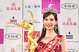Karolina Shiino poses for photos with a gold Miss Japan trophy. 