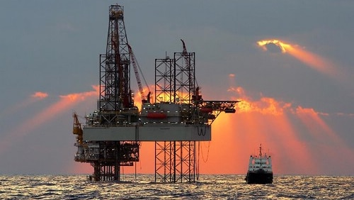 An offshore oil rig at sunset