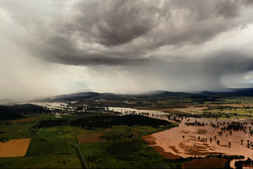 Rain falling from clouds across crop fields.