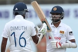 Two Sri Lankan male cricketers celebrate against Australia in second Test in Galle.