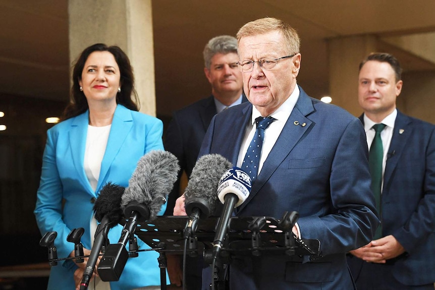 John Coates, with Annastacia Palaszczuk behind him, speaking to media in Brisbane.