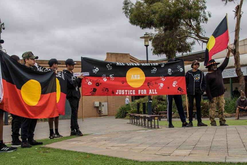 Protesters display Aboriginal flags in St Barbara's Square in Kalgoorlie.