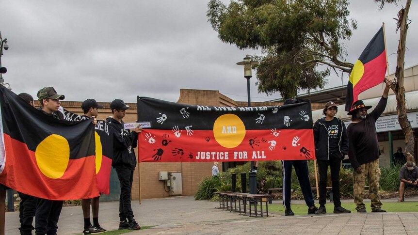 Protesters display Aboriginal flags in St Barbara's Square in Kalgoorlie.