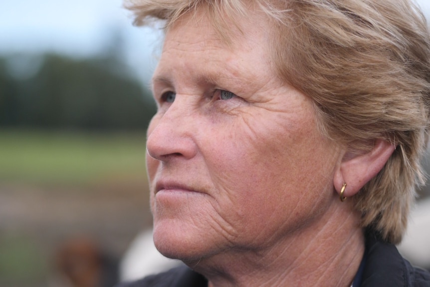 close shot of face of woman with cropped blonde hair and blue eyes