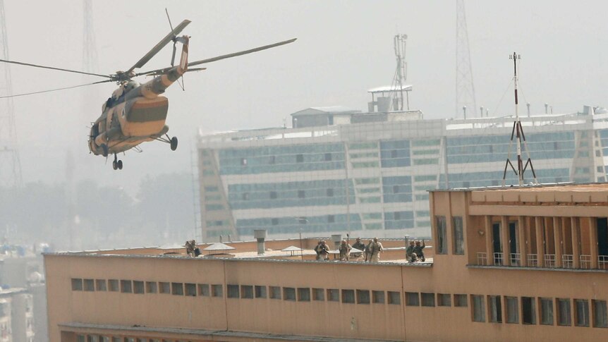 Soldiers enter a hospital under siege in Kabul from the roof after being dropped off by a helicopter.
