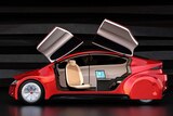 The side view of an autonomous car with doors that open upwards, the seats are turned to face each other.